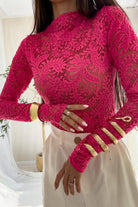 Blusa aderente fucsia con maniche lunghe in pizzo elasticizzato a fantasia floreale, marca Moda-Mania.