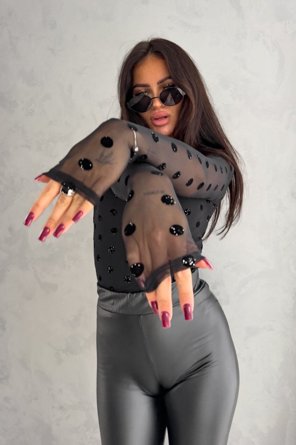 Blusa aderente nera Moda-Mania, maniche lunghe in tulle elasticizzato a pois con fantasia floreale.