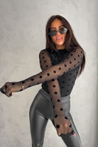 Blusa aderente nera a maniche lunghe in tulle elasticizzato con pois e fantasia floreale, marca Moda-Mania.
