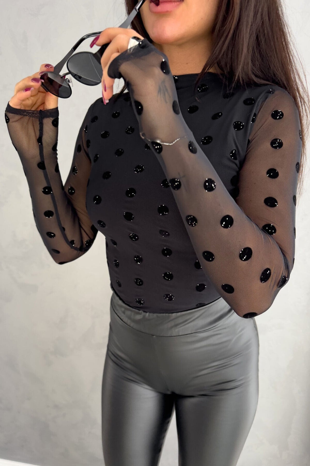 Blusa aderente nera a maniche lunghe in tulle elasticizzato con fantasia floreale, marca Moda-Mania.