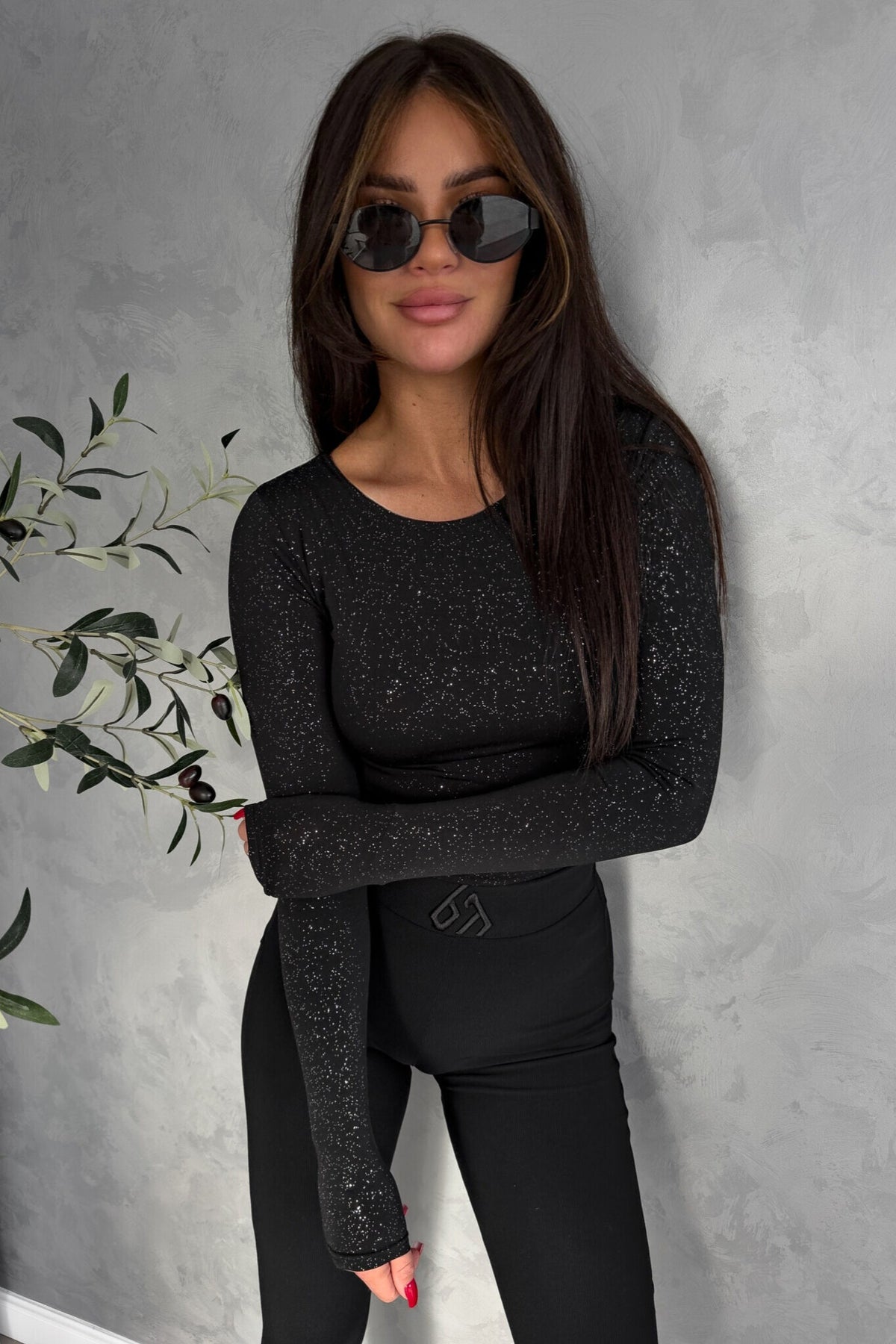 Blusa aderente nera Moda-Mania con maniche lunghe in tessuto glitterato elasticizzato, perfetta per un look elegante e moderno.