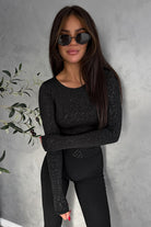 Blusa aderente nera Moda-Mania con maniche lunghe in tessuto glitterato elasticizzato, perfetta per un look elegante e moderno.