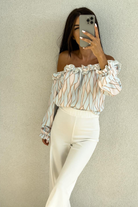 Blusa celeste a fantasia astratta con scollo a barchetta e rifiniture rouches, marca Moda-Mania, vista frontale.