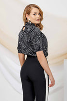 Blusa elegante nera a stampa maculata bianca Pretty Girl con collo alto e apertura, visibile in questa immagine.