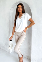 Blusa estiva bianca Moda-Mania con maniche corte e scollo a V dorato, tessuto leggero e stile elegante.