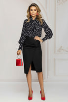 Blusa nera a fantasia pois Pretty Girl con collo alto e dettaglio jabout, visibile in primo piano, tessuto morbido e femminile.