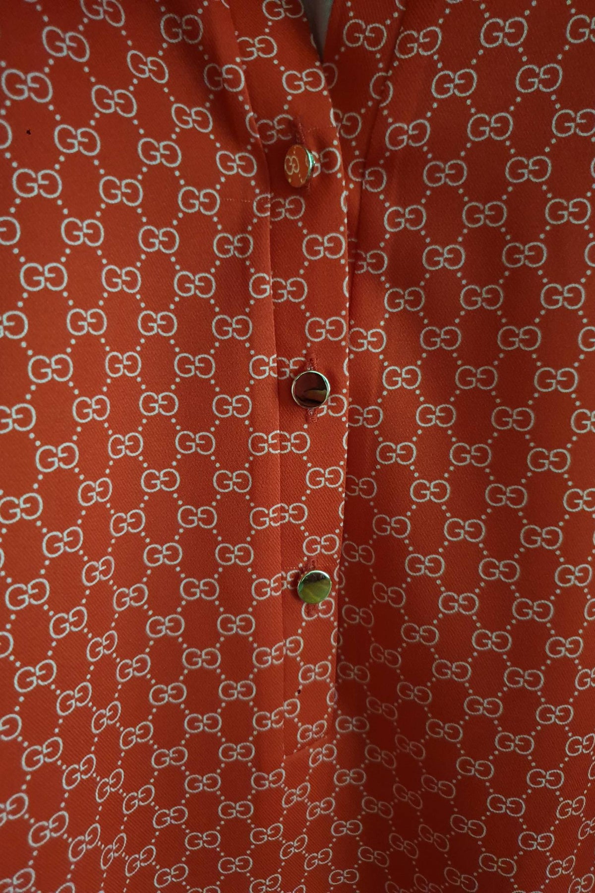 Blusa rossa corallo stampa G con scollo a V alla coreana e bottoni dorati, di Moda-Mania, vista frontale e dettagli di design.