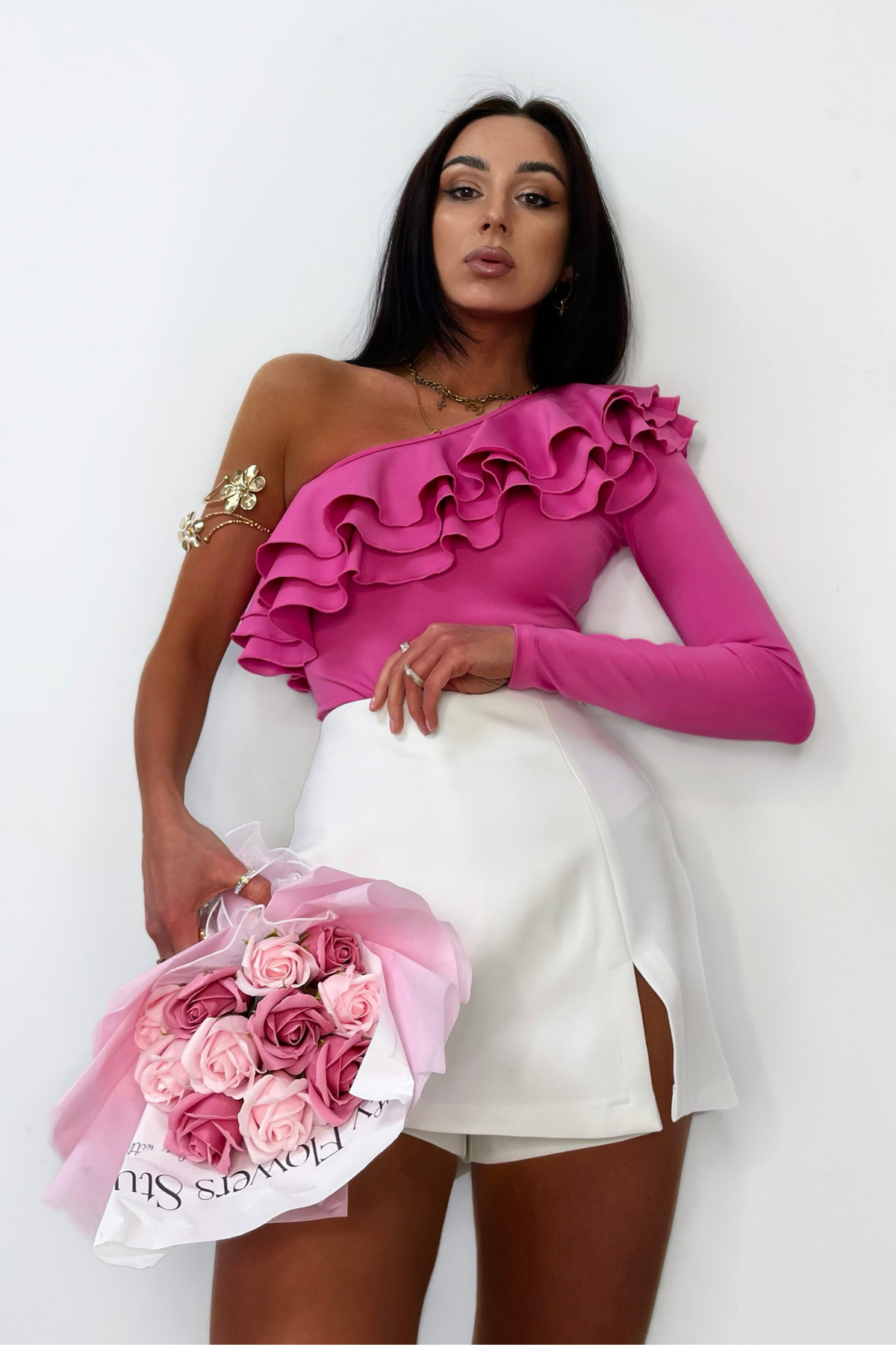 Body fucsia elasticizzato Moda-Mania con monospalla, monomanica e tripli volants, vestibilità aderente e stile elegante.