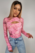Body rosa Moda-Mania con motivo astratto, foro del dito del pollice sul polsino e apertura sul décolleté.