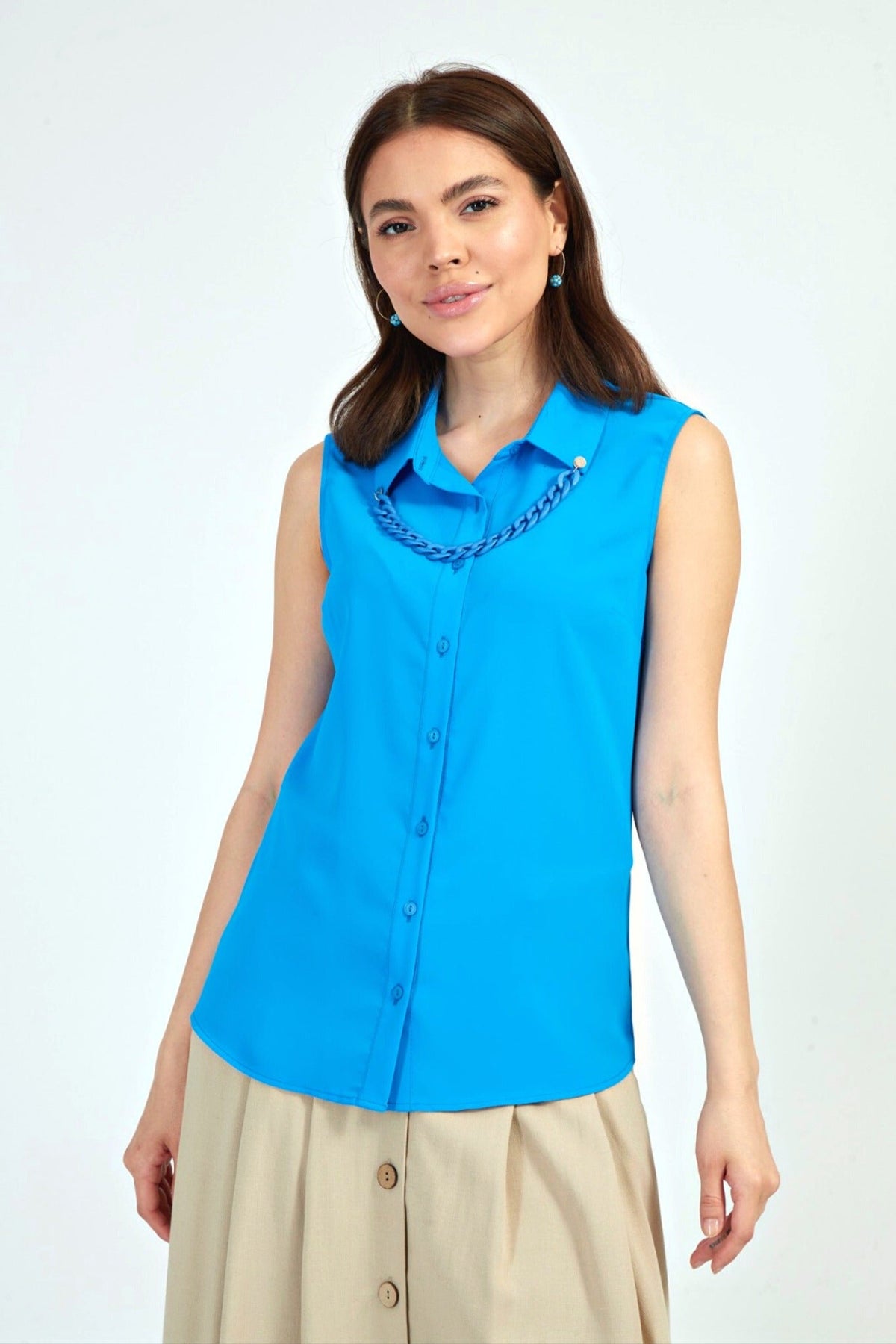 Camicia blu azzurro senza maniche di Moda-Mania con catenella nera rimovibile e dettagli accessoriati, vista frontale.