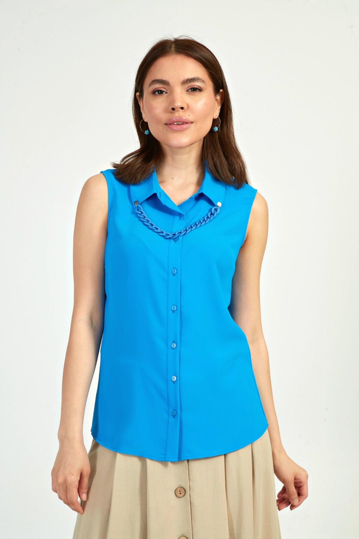 Camicia blu azzurro senza maniche di Moda-Mania, accessoriata con catenella nera rimovibile, dettaglio visibile sull'immagine.