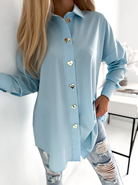 Camicia oversize celeste Moda-Mania con bottoni dorati a forma di cuore, lunga e ampia, tessuto leggero e morbido.