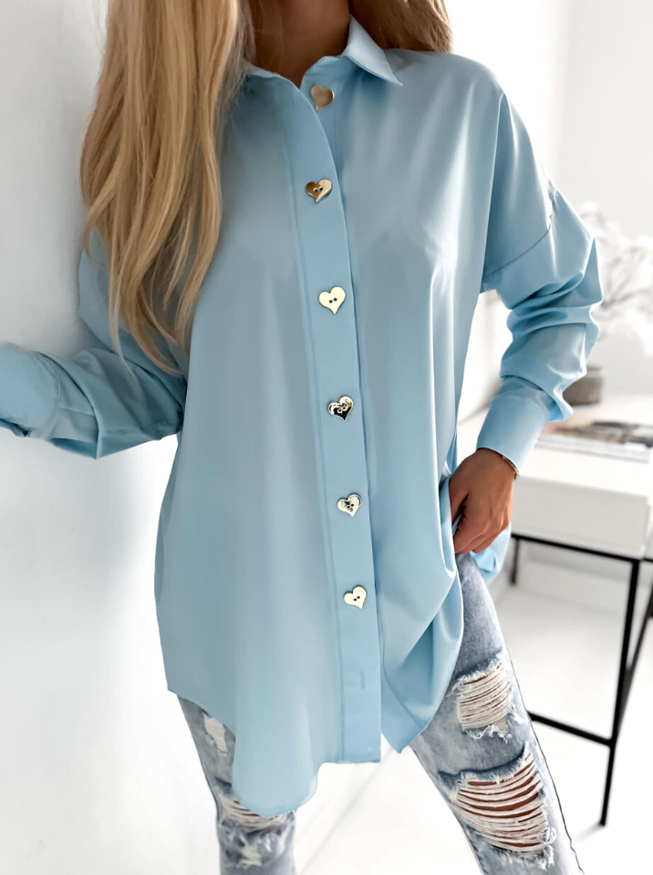 Camicia oversize celeste Moda-Mania con bottoni dorati a forma di cuore, lunga e ampia, tessuto leggero e morbido.