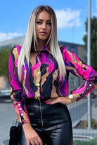 Camicia elegante Moda-Mania con fantasia astratta fucsia, dorato, nero e viola, dettagli con bottoni dorati, tessuto leggero e raffinato.