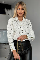 Camicia elegante bianca con fantasia nera, bottoni dorati, marca Moda-Mania, mostra dettagli della camicia con bottoni dorati.