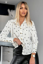 Camicia elegante bianca a fantasia nera di Moda-Mania con bottoni dorati, tessuto raffinato e dettagli di stile sofisticato.