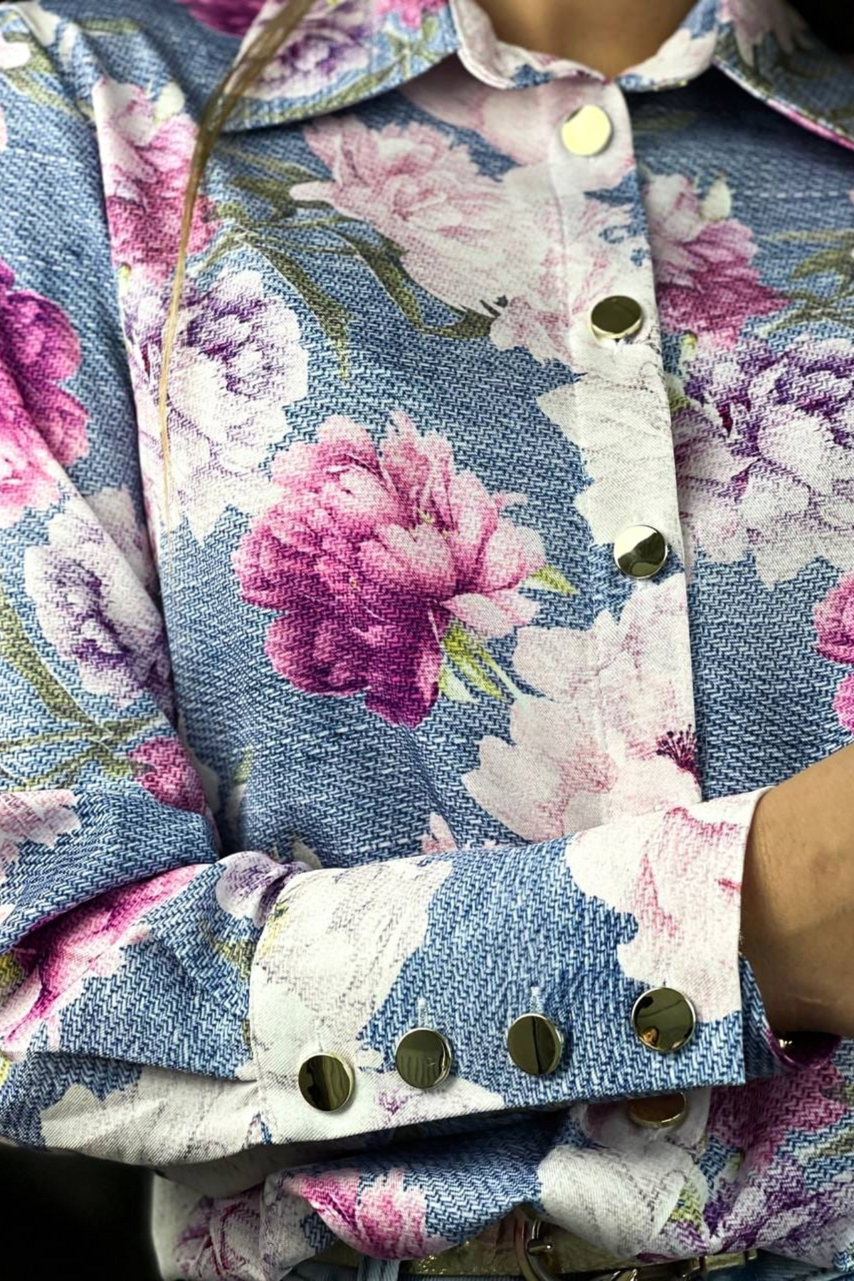 Camicia elegante bianca Moda-Mania con fantasia floreale rosa e bottoni dorati, tessuto leggero e stile raffinato.