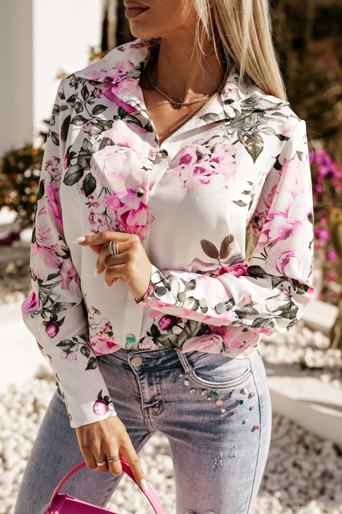 Camicia elegante bianca Moda-Mania con fantasia floreale rosa e fucsia, bottoni dorati, tessuto leggero e dettagli raffinati