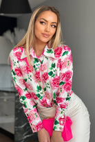 Camicia elegante bianca Moda-Mania con fantasia floreale rosa, dettagli di bottoni dorati, tessuto leggero e stile raffinato