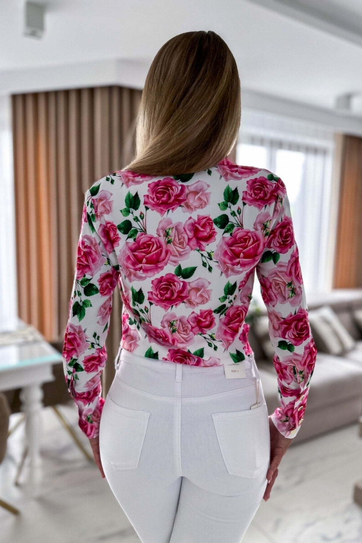 Camicia elegante bianca Moda-Mania con fantasia floreale rosa, bottoni dorati e dettagli raffinati.