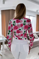 Camicia elegante bianca Moda-Mania con fantasia floreale rosa, bottoni dorati e dettagli raffinati.