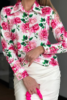 Camicia elegante bianca Moda-Mania con fantasia floreale rosa e bottoni dorati, tessuto leggero e dettagli raffinati.