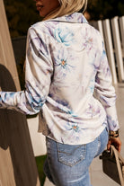 Camicia elegante bianca Moda-Mania con fantasia floreale viola chiaro e celeste, bottoni dorati e classica vestibilità.