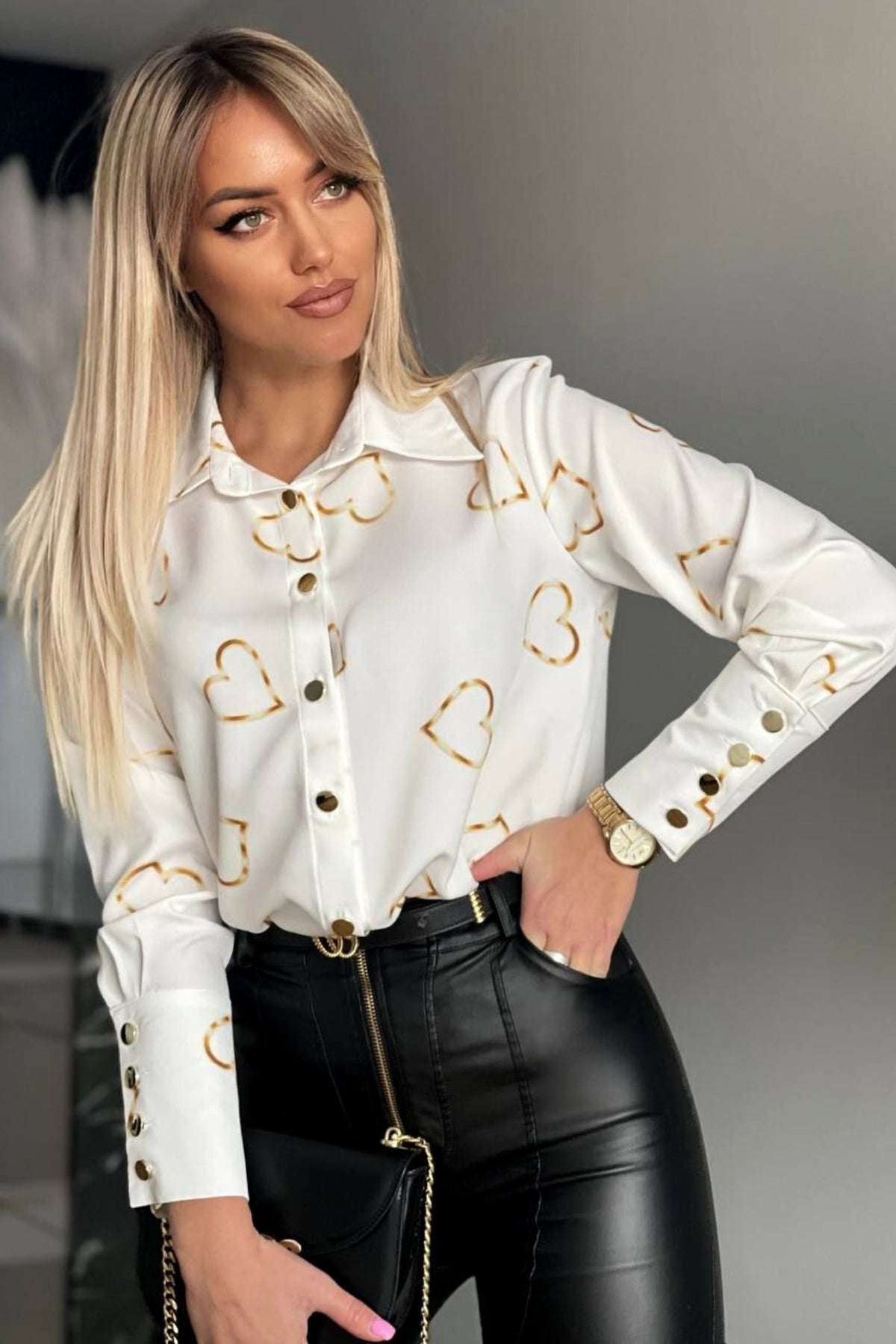 Camicia elegante bianca Moda-Mania con stampa cuori dorati e bottoni dorati, tessuto leggero e dettagli raffinati.