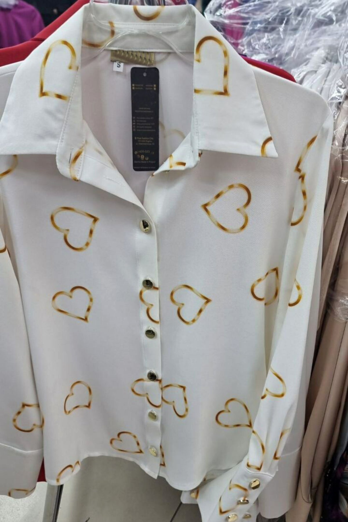 Camicia elegante bianca Moda-Mania con stampa cuori dorati e bottoni dorati, tessuto leggero e stile raffinato.