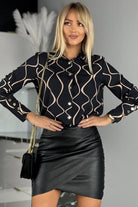 Camicia elegante nera con fantasia astratta beige e bottoni dorati, moda-mania, tessuto leggero e dettagli raffinati.