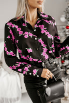 Camicia elegante nera Moda-Mania con fantasia di piccole rose fucsia e bottoni dorati, tessuto leggero e stile raffinato.