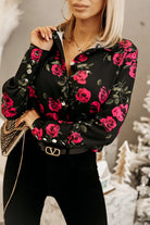 Camicia elegante nera Moda-Mania con fantasia di rose rosse, foglie verdi e bottoni dorati, tessuto leggero e dettagli raffinati.