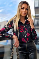 Camicia elegante nera Moda-Mania con fantasia di rose rosse e foglie verdi, bottoni dorati, dettagli raffinati.