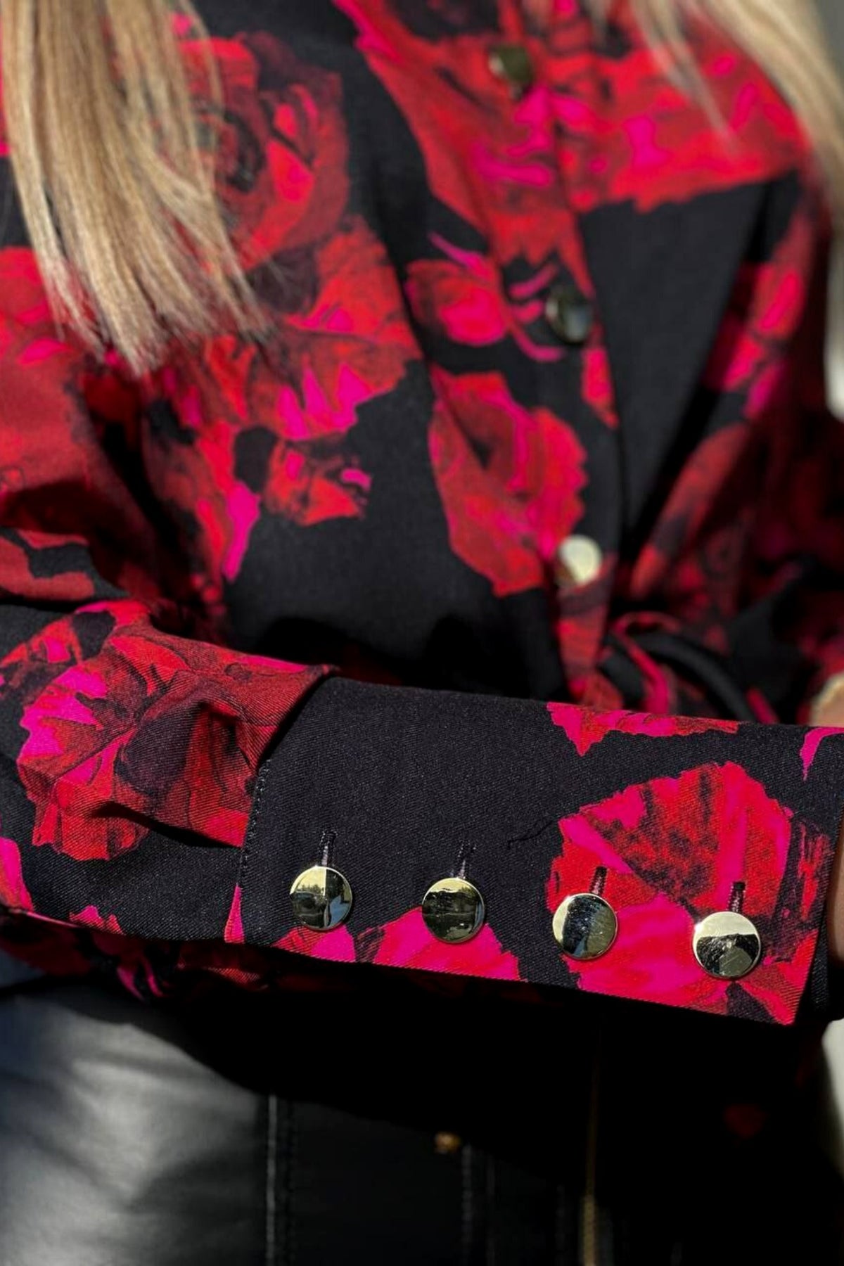 Camicia elegante nera Moda-Mania con fantasia di rose rosse e fucsia, bottoni dorati, tessuto raffinato e dettagli femminili.