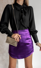 Camicia elegante nera Moda-Mania con colletto asimmetrico, volant e bottoni gioiello, tessuto morbido e dettagli raffinati.