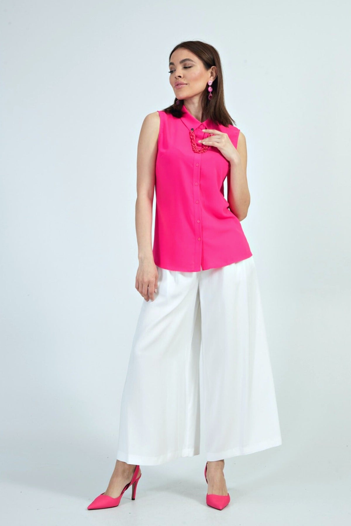 Camicia fucsia senza maniche della Moda-Mania con catenella nera rimovibile, dettagli eleganti e tessuto leggero.