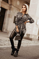 Camicia lunga fantasia pitonata beige e marrone con spacchi laterali e cinturino, modello Moda-Mania, tessuto leggero e elegante.
