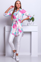 Camicia lunga bianca Moda-Mania con fantasia foglie, spacchi laterali e cinturino in tessuto leggero e elegante.