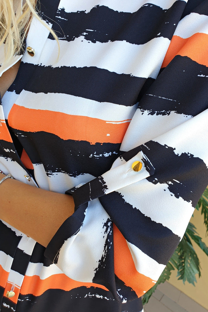 Camicia lunga bianca a fantasia righe nere e arancione con spacchi laterali e cinturino