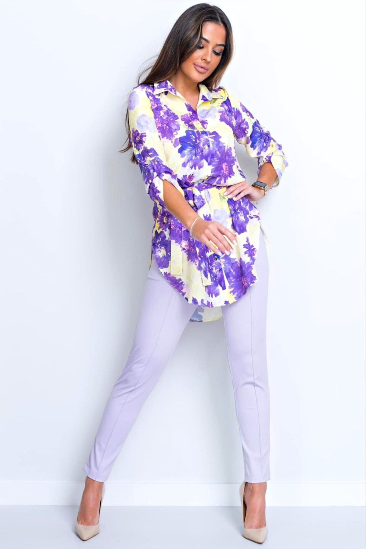 Camicia lunga giallo pastello Moda-Mania con fantasia floreale violetto, spacchi laterali e cinturino, tessuto leggero e elegante.