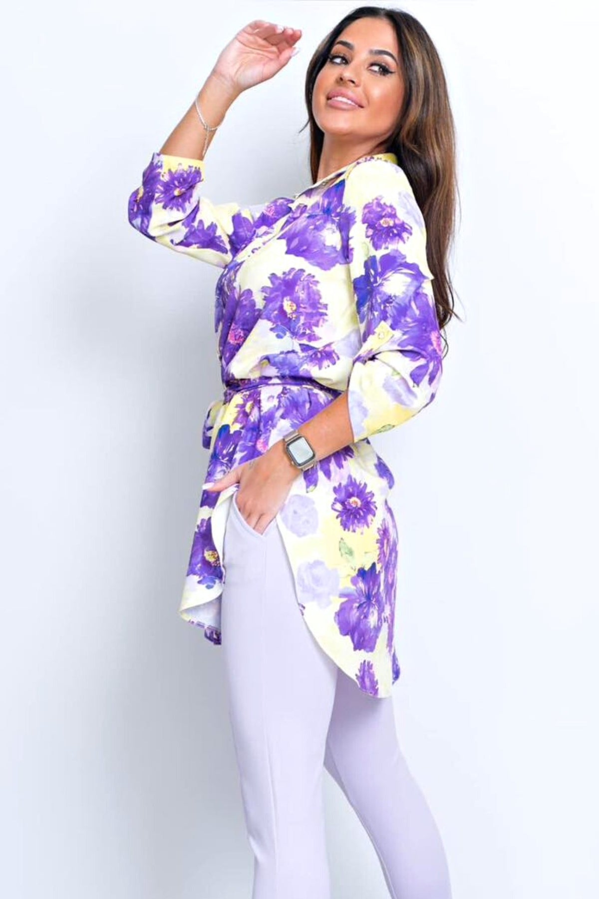 Camicia lunga Moda-Mania giallo pastello con fantasia floreale viola, spacchi laterali e cinturino, tessuto leggero e elegante.