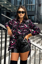 Camicia lunga oversize nera Moda-Mania con scritte rosa, magenta e viola, tessuto comodo e stile casual.