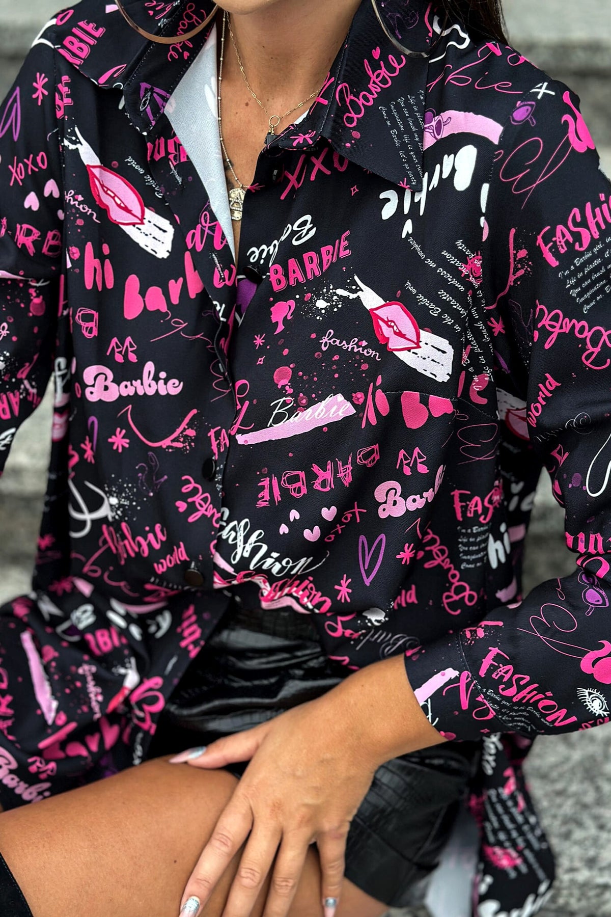 Camicia lunga oversize nera Moda-Mania con scritte rosa, magenta e viola, tessuto comodo e stile casual elegante.