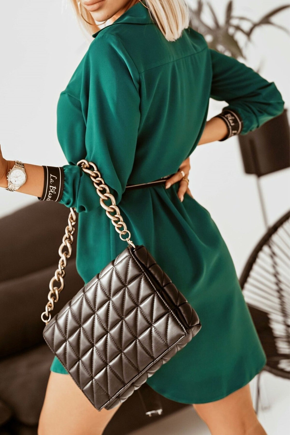 Camicia lunga verde scuro asimmetrica Moda-Mania con cintura e polsini neri, dettagli alla moda e stile elegante.
