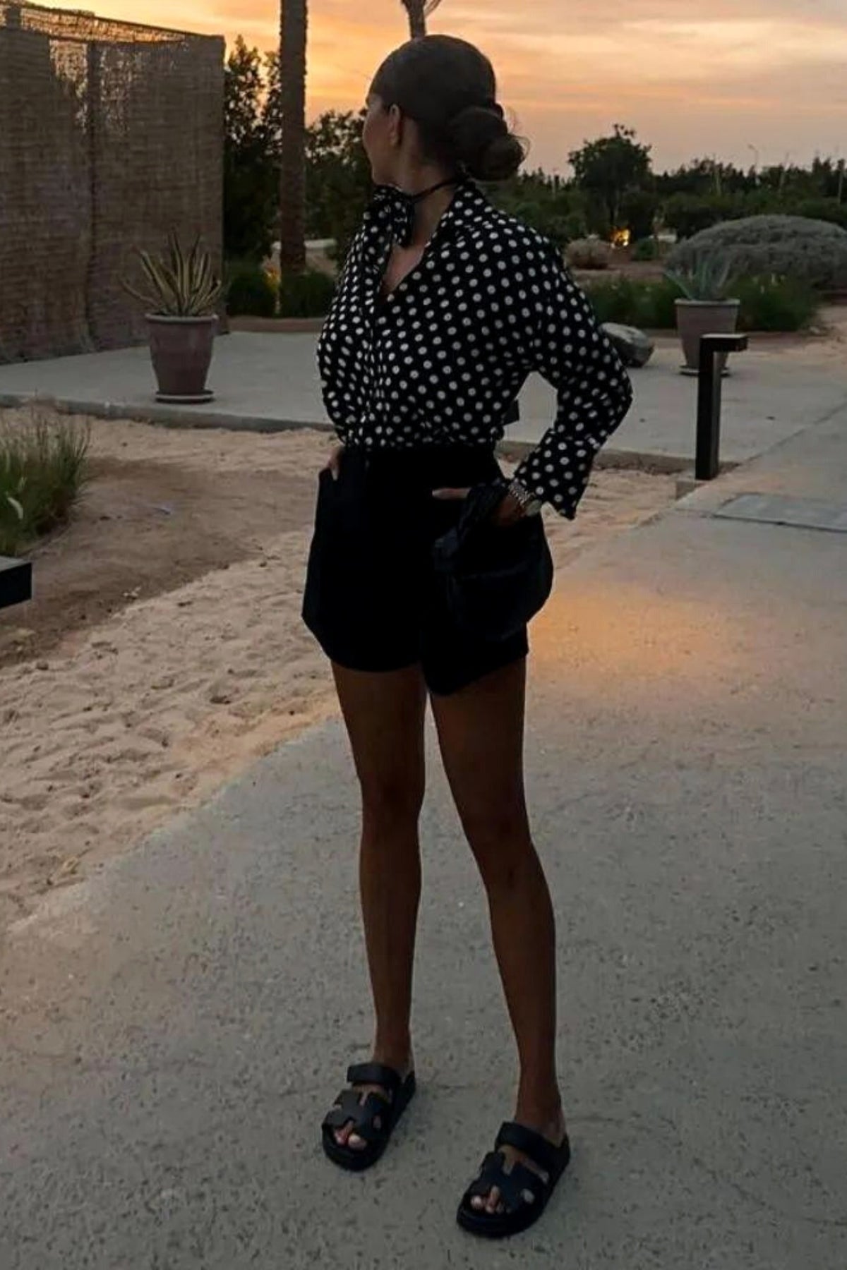 Camicia nera a pois bianchi in viscosa di Moda-Mania, con fiore in tessuto come dettaglio decorativo.