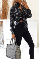 Camicia nera in viscosa con pois bianchi e fiore in tessuto come accessorio, stile Moda-Mania, vestibilità elegante e casual.