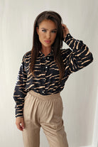 Camicia nera larga in viscosa con fantasia zebrata beige e bottoni dorati, stile casual e alla moda.