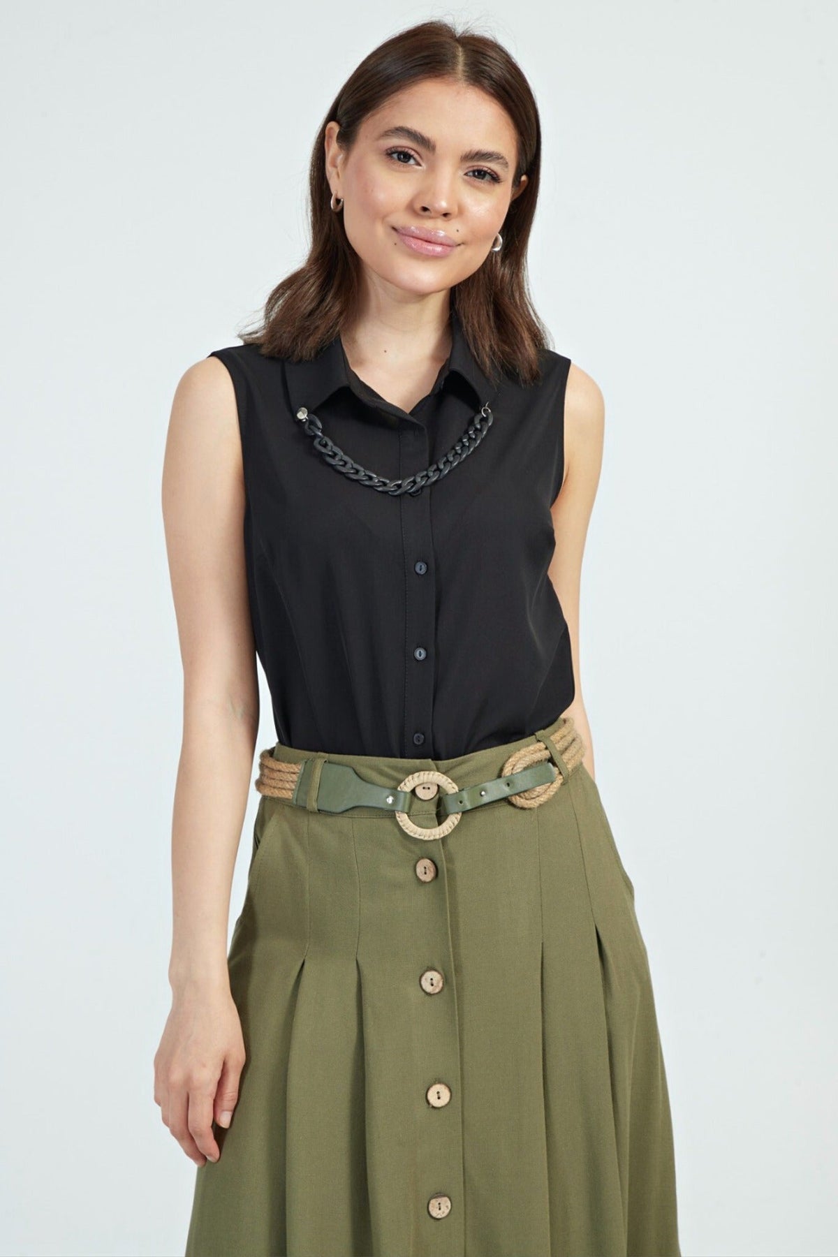 Camicia nera senza maniche moda-mania con catenella rimovibile, dettagli eleganti e stile moderno, visibile in primo piano.