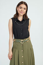 Camicia nera senza maniche moda-mania con catenella rimovibile, dettagli eleganti e stile moderno, visibile in primo piano.