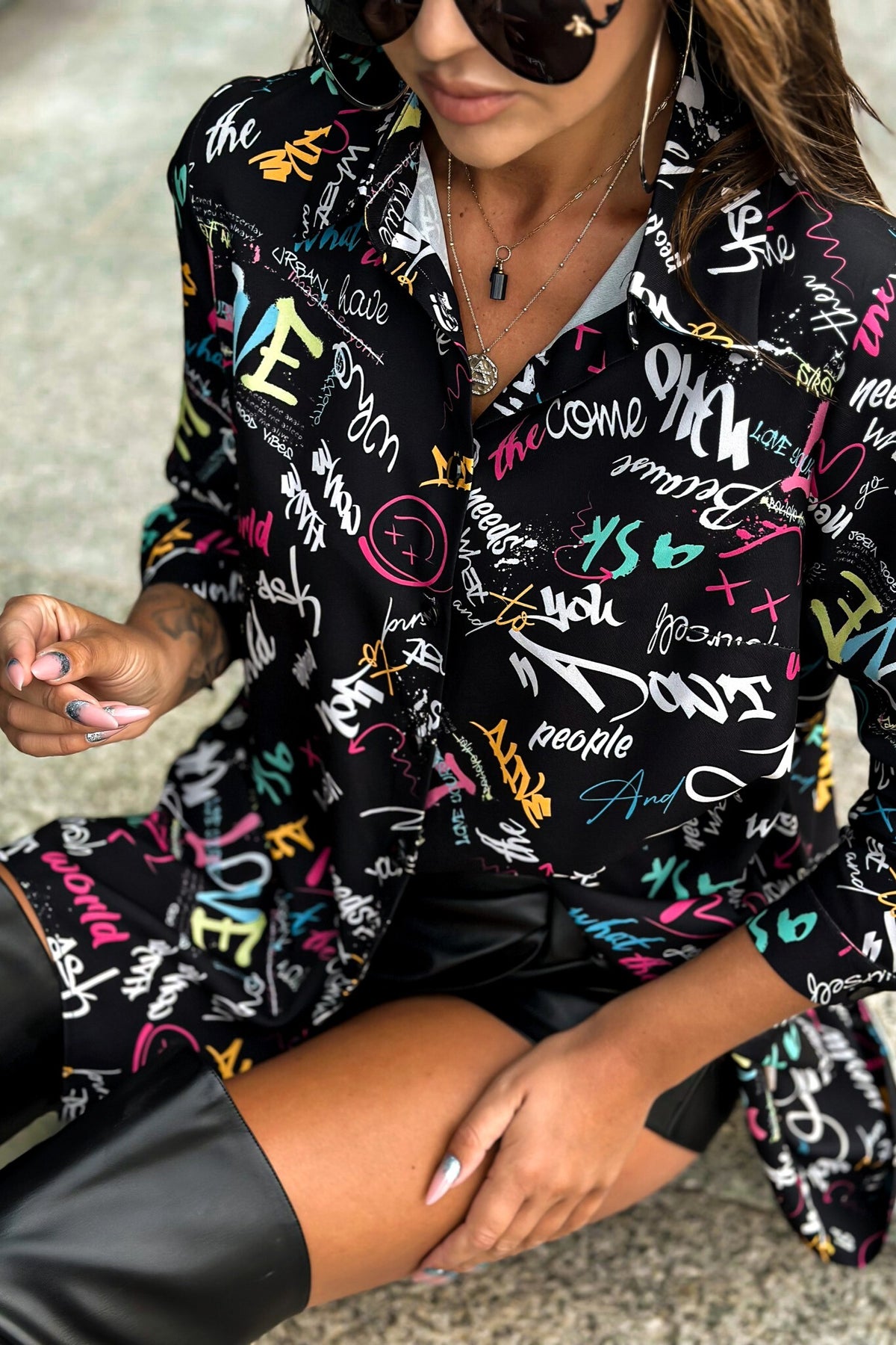 Camicia oversize nera Moda-Mania con scritte multicolore, stile casual e moderno, visibile in dettaglio nell'immagine.